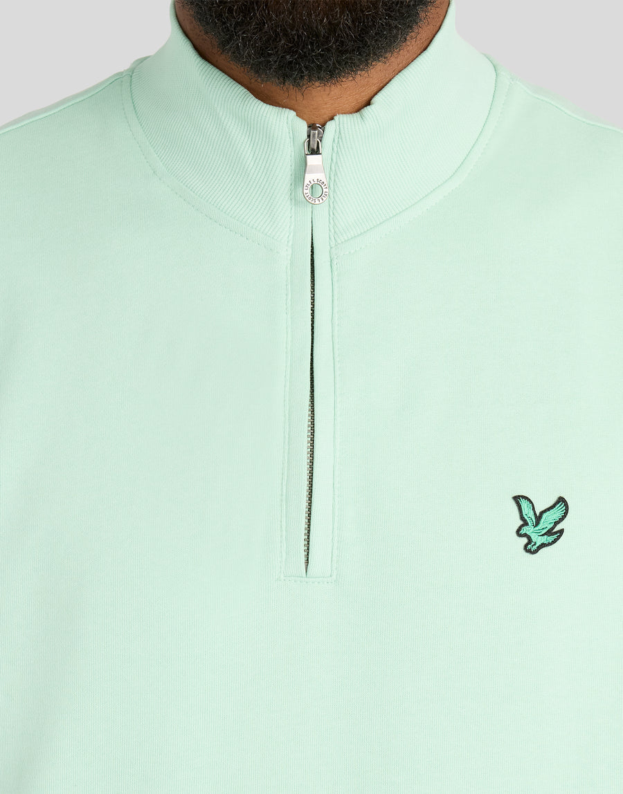 Mann trägt ein „Green Eagle Cotton 1/4 Zip Midlayer“-Shirt in der Farbe „Morning Mint“