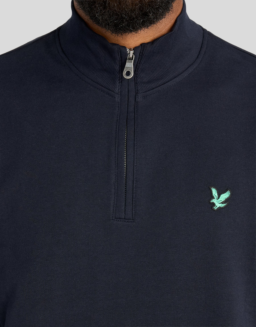 Mann trägt ein „Green Eagle Cotton 1/4 Zip Midlayer“ in Dunkelblau