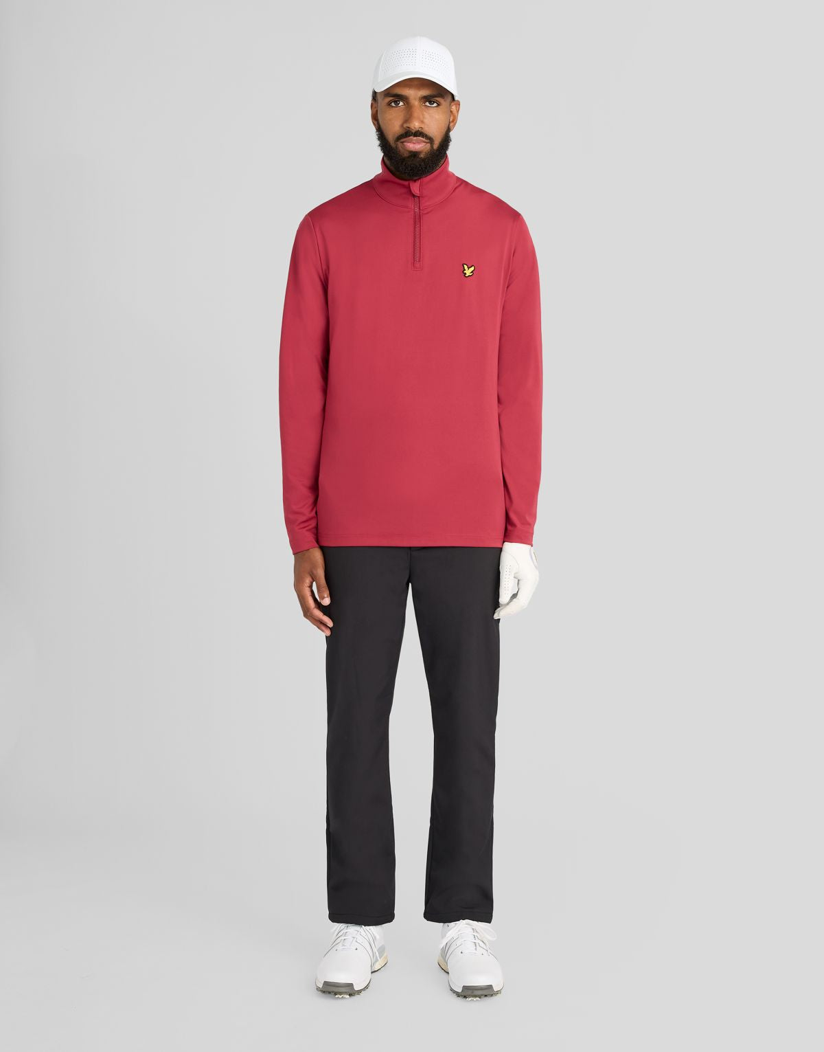 Un hombre lleva una camiseta de entrecapa Performance con cremallera de 1/4 en color ciruela