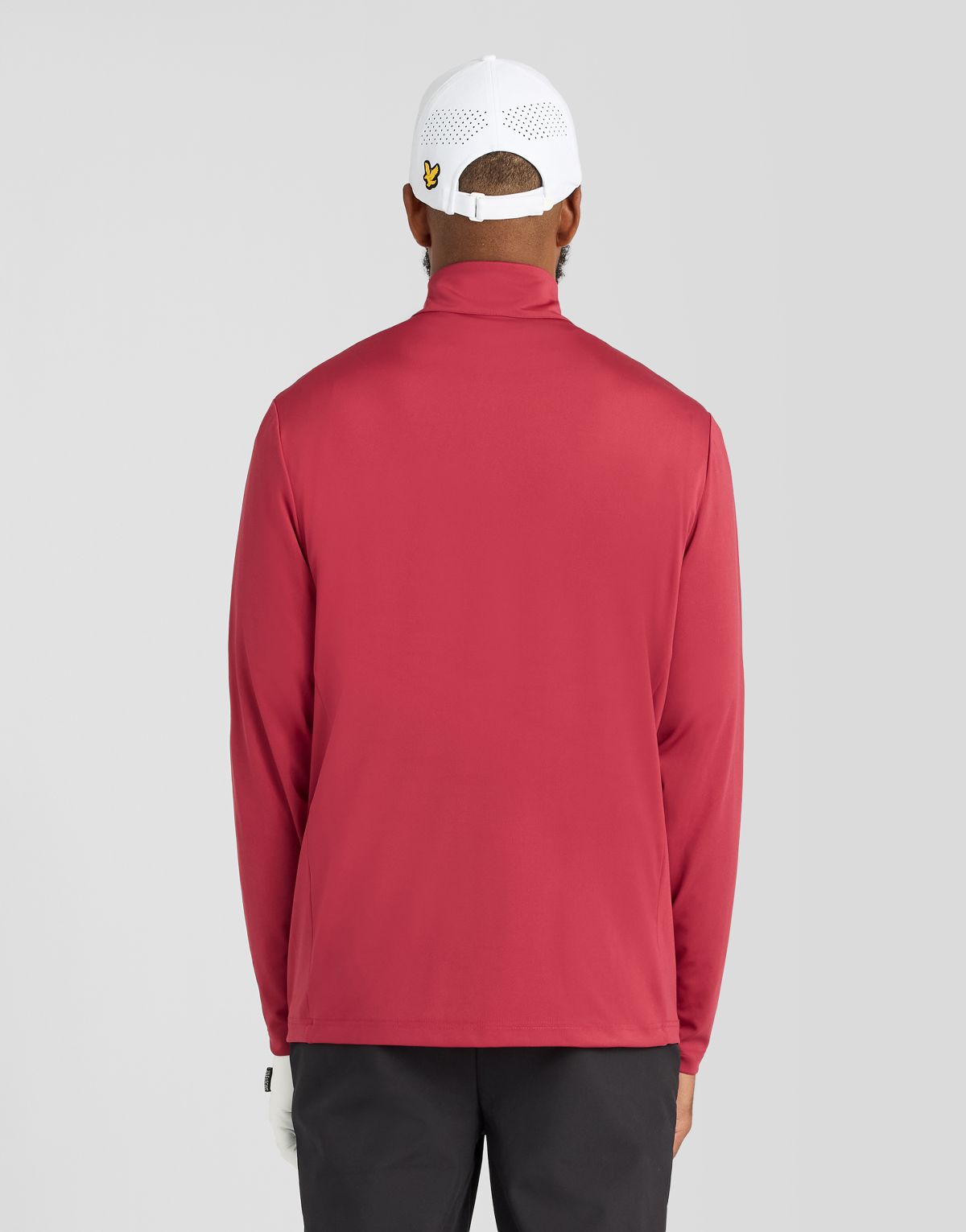 Un hombre lleva una camiseta de entrecapa Performance con cremallera de 1/4 en color ciruela