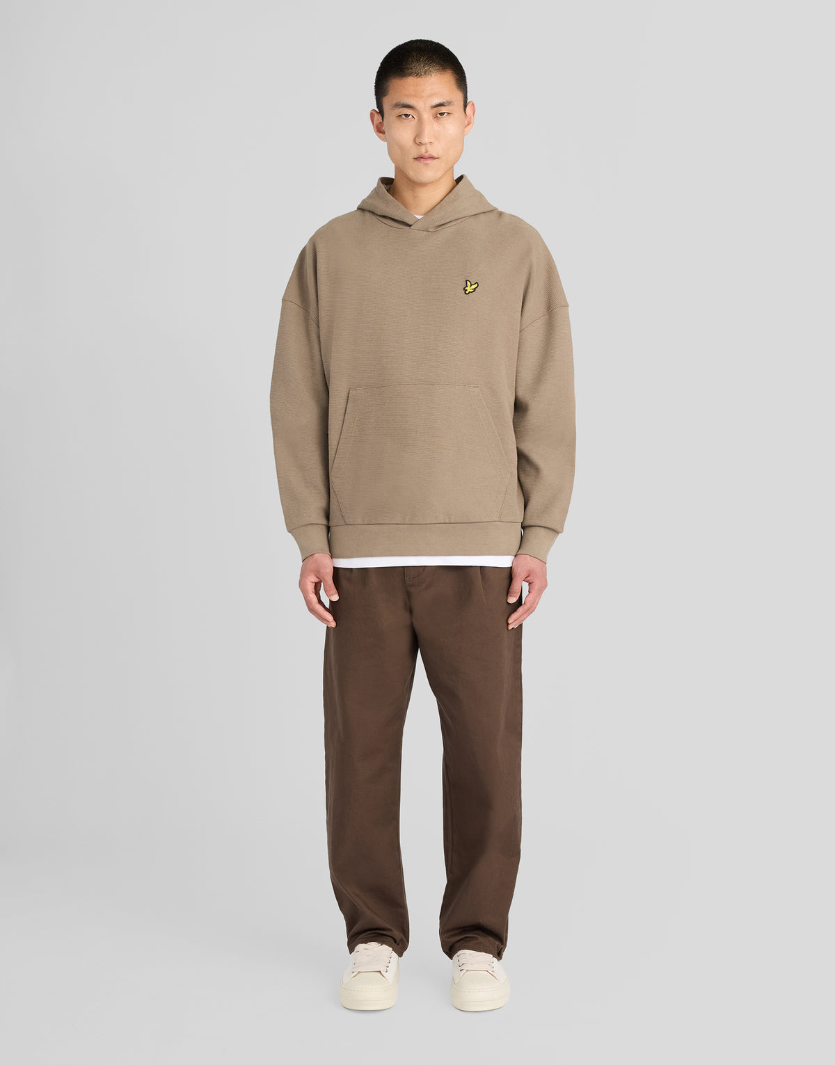 Mann in einem Hoodie mit strukturiertem Rippmuster in der Farbe „Khaki Ash“