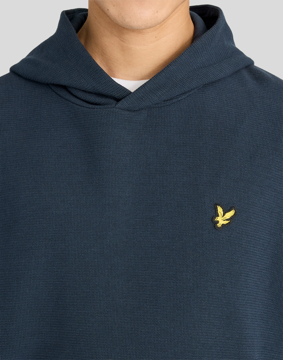 Uomo che indossa una felpa con cappuccio a costine testurizzate in blu navy scuro