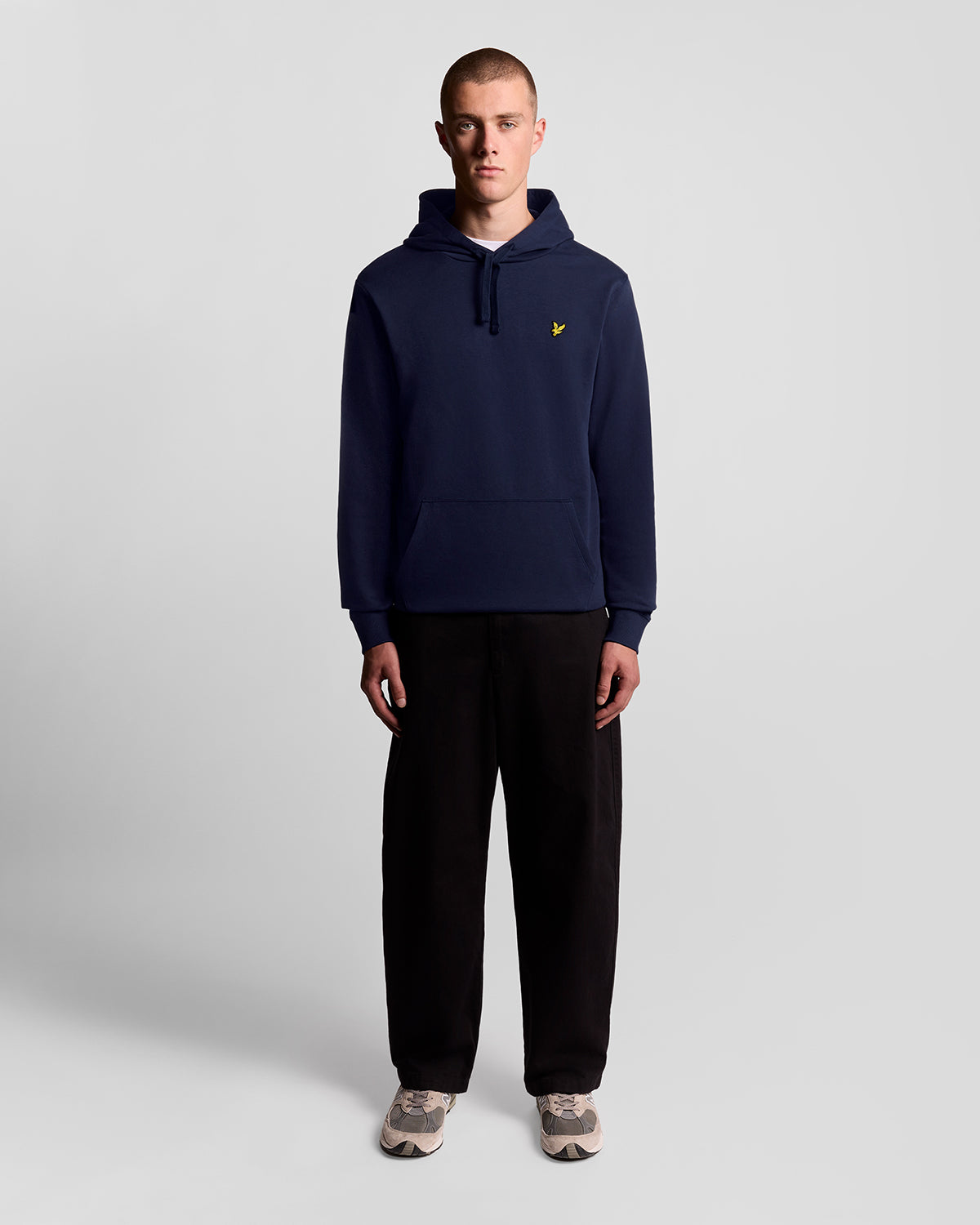 Un homme porte un sweat à capuche en coton Loopback bleu marine