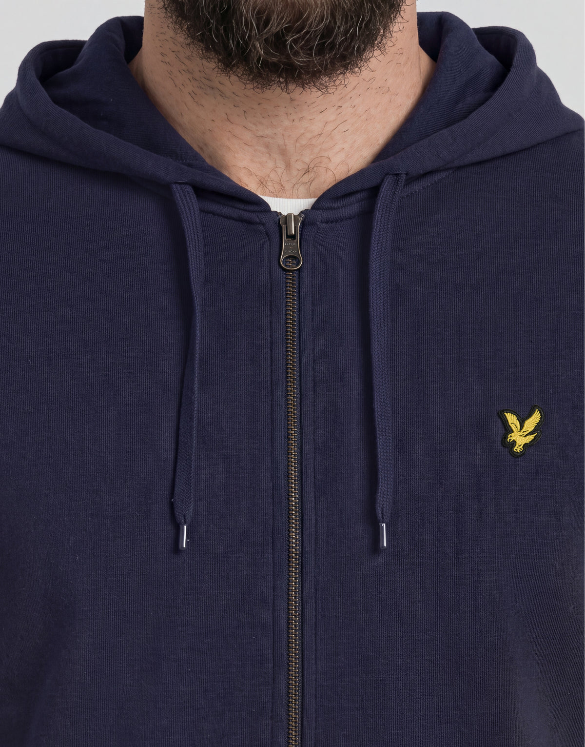 Homme portant un sweat à capuche en coton « loopback » à fermeture éclair intégrale, taille grande et longue, couleur bleu marine