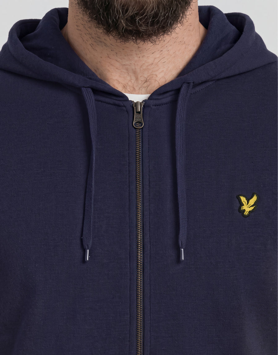 Homme portant un sweat à capuche en coton « loopback » à fermeture éclair intégrale, taille grande et longue, couleur bleu marine