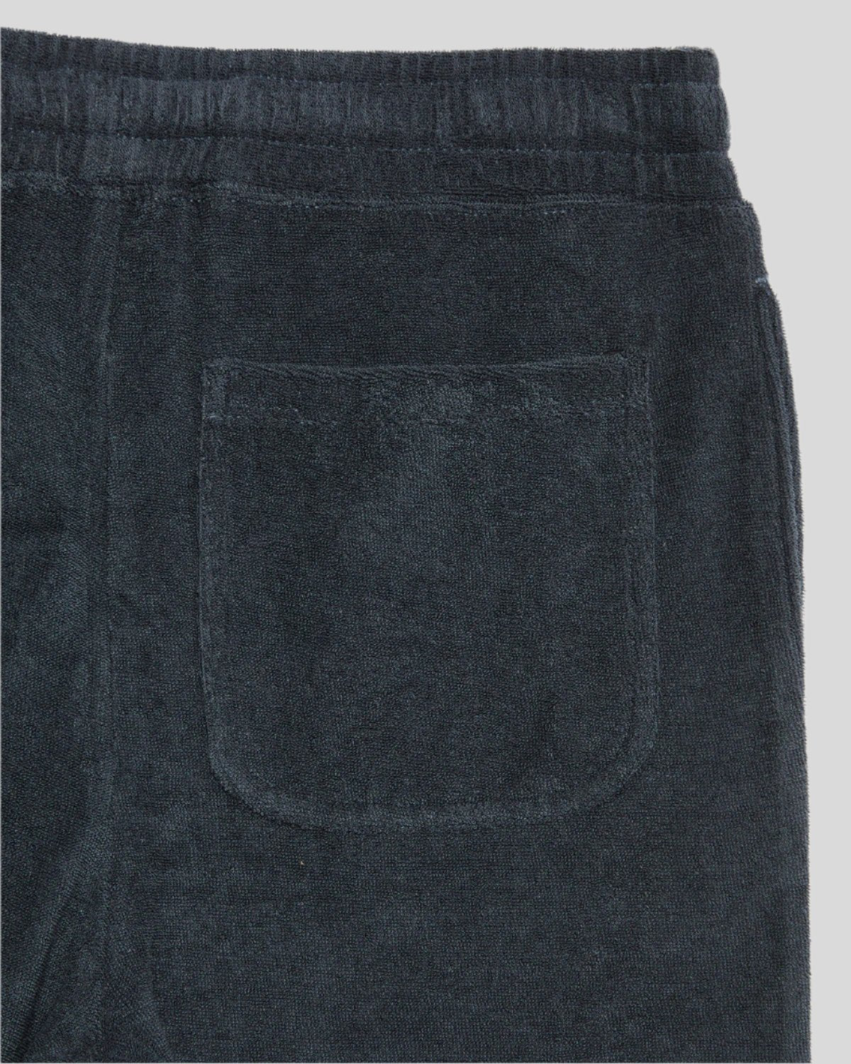 Junge trägt Frottee-Shorts in Dunkelblau