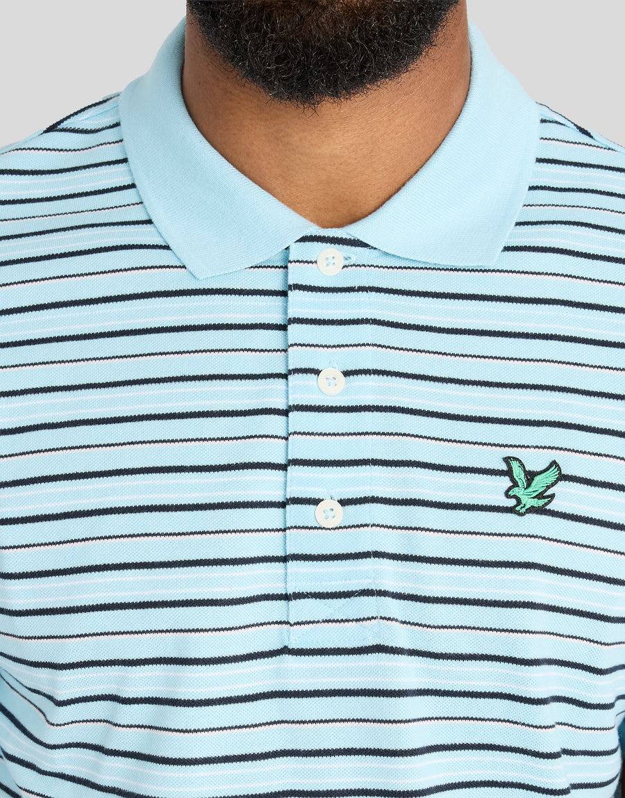 Mann trägt ein gestreiftes „Green Eagle“-Polohemd in den Farben „Sea Breeze Blue“ / „Dark Navy“ und „Subtle Pink“
