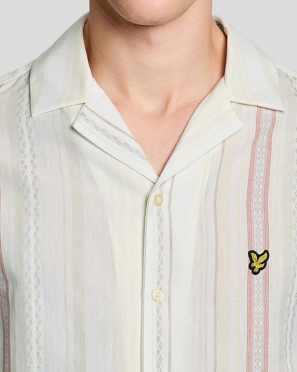 Un homme porte une chemise à manches courtes à rayures en zigzag, couleur naturelle