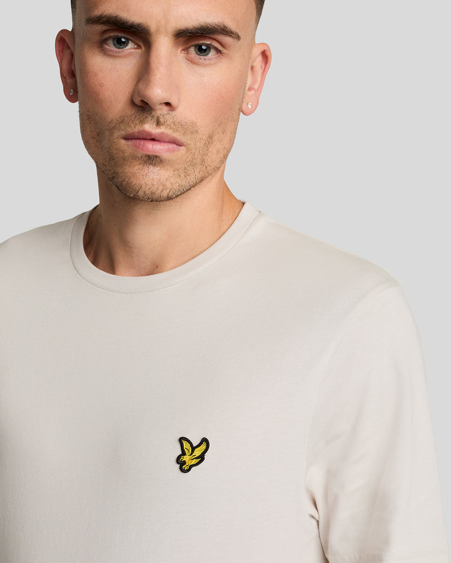 Un homme porte un t-shirt en coton à col rond de couleur Cove