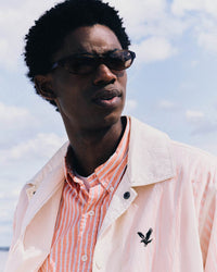 Casual men's outfit featuring a striped shirt and a translucent jacket with the Lyle and Scott eagle logo