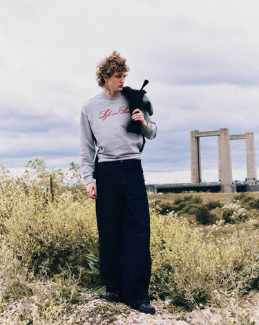 Conjunto informal para hombre compuesto por una sudadera bordada en la que se combina un entorno rural con elementos de infraestructura urbana