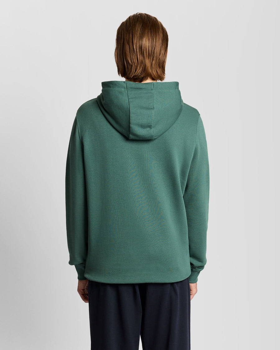 L'uomo indossa una felpa con cappuccio Loopback in cotone color Everglade