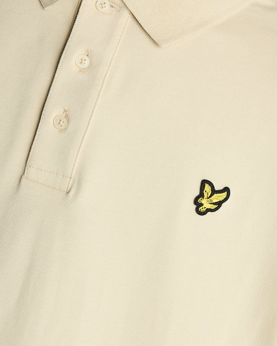 Un homme porte un polo en coton couleur blé