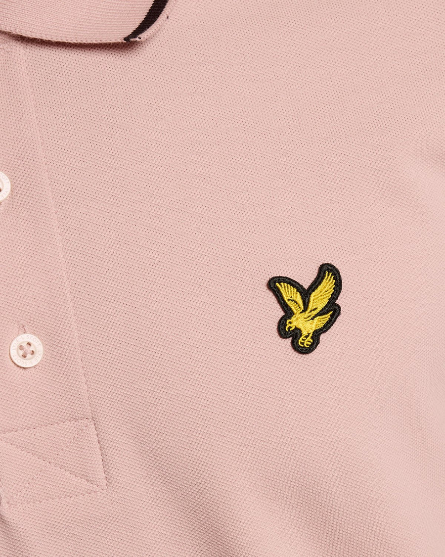 Homme portant un polo à rayures rose pamplemousse et bleu marine foncé