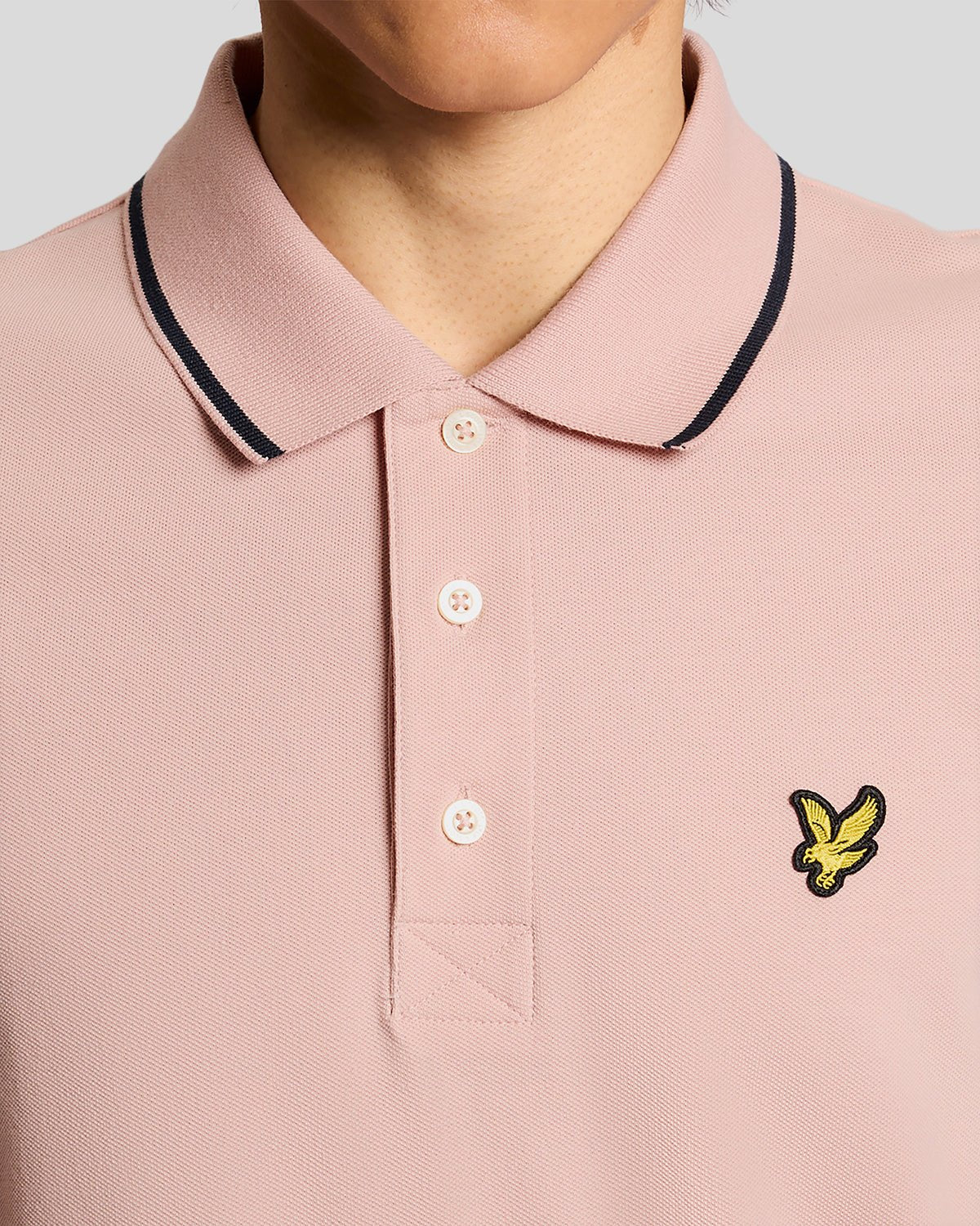 Homme portant un polo à rayures rose pamplemousse et bleu marine foncé