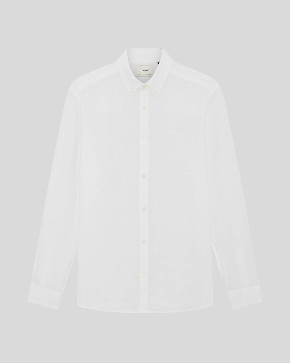 Un homme porte une chemise en lin boutonnée, de couleur blanche