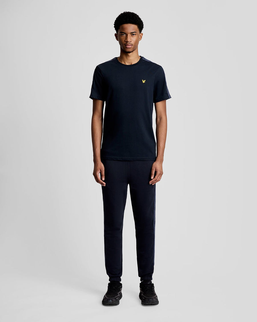 Hombre lleva camiseta deportiva con cinta jacquard en azul marino oscuro.