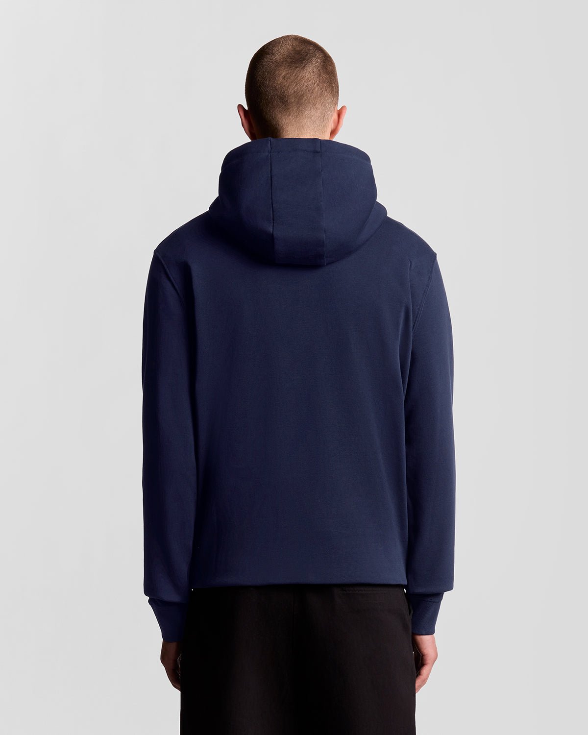 Un homme porte un sweat à capuche en coton Loopback bleu marine