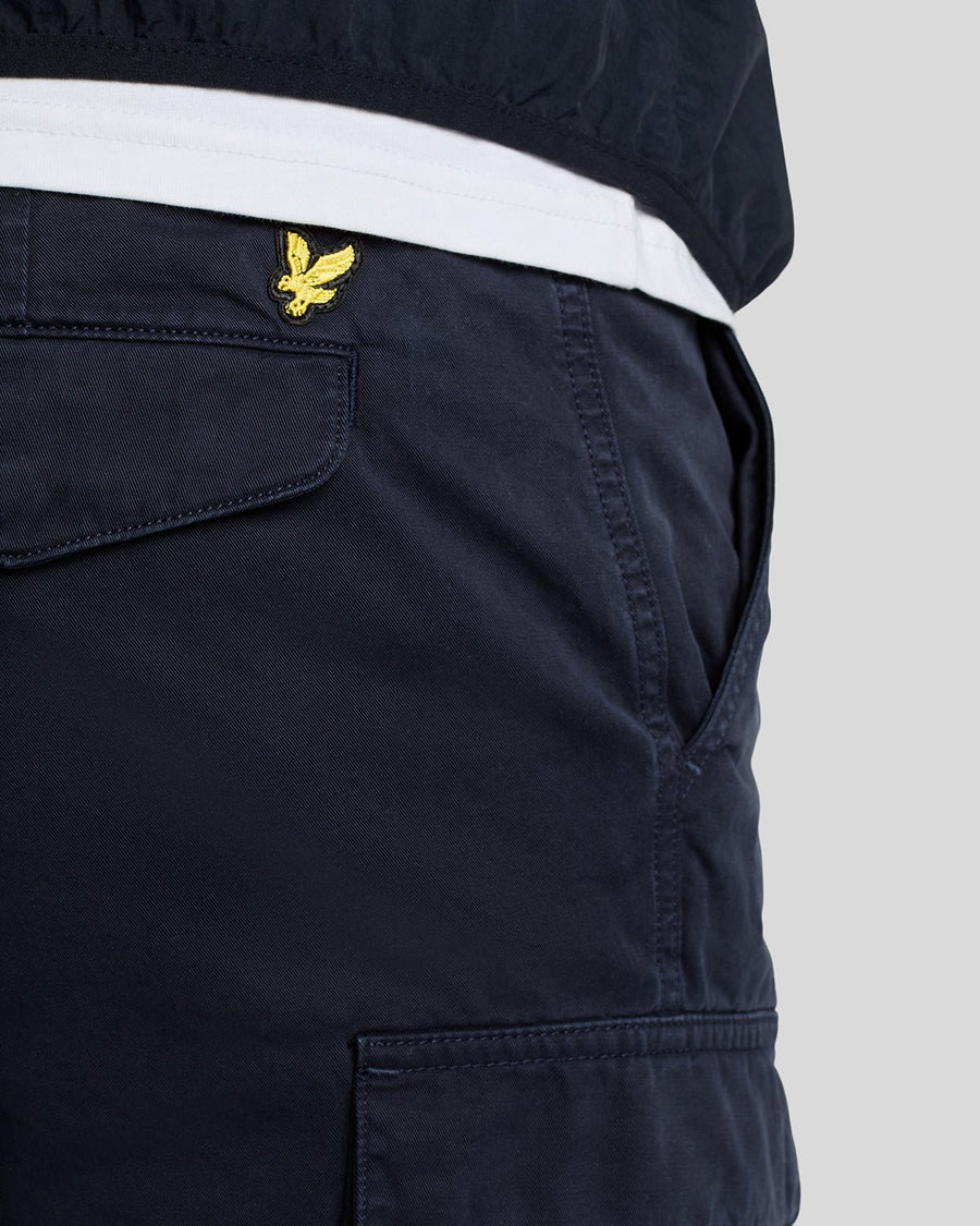 Un homme porte un short cargo bleu marine foncé