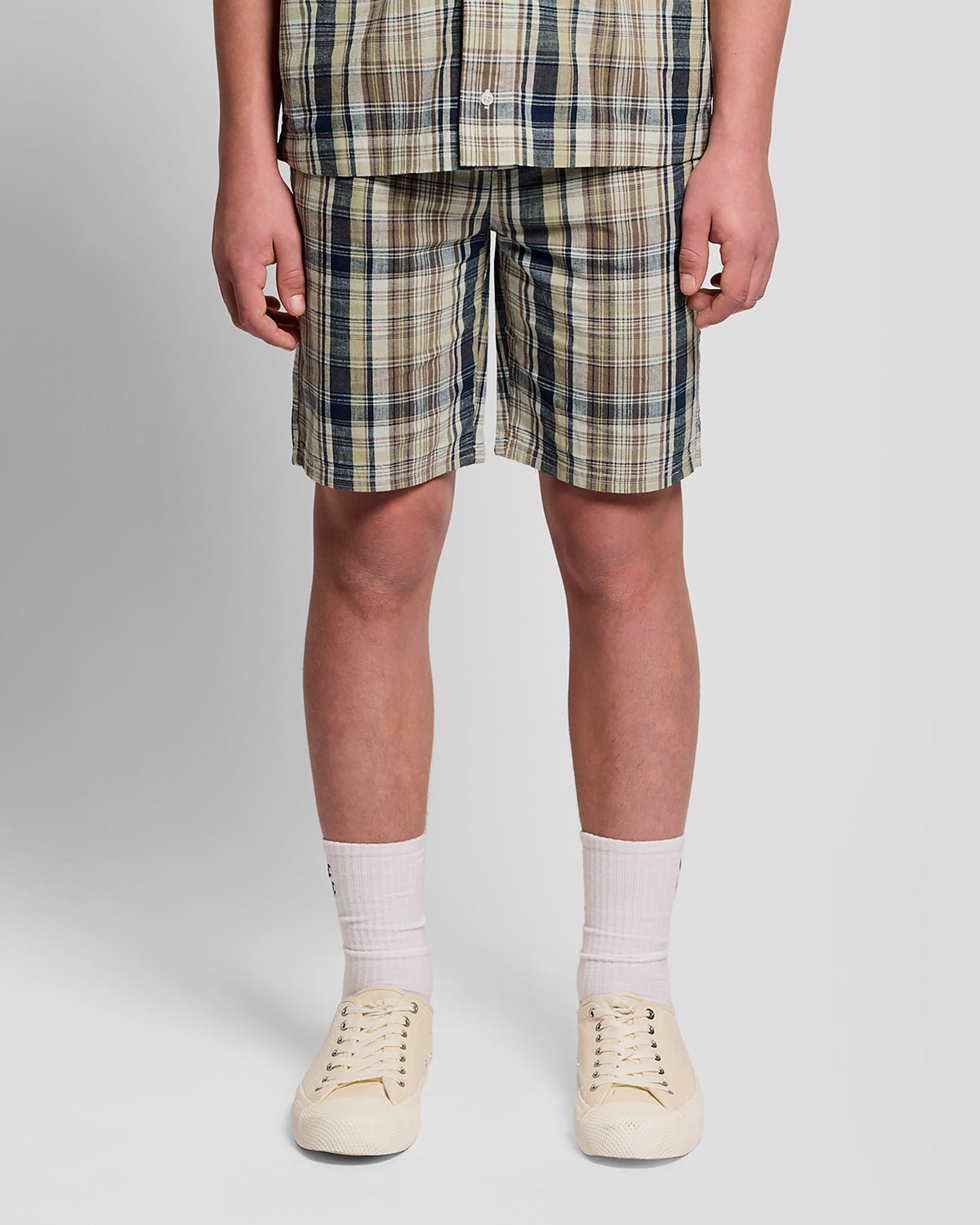 Uomo con pantaloncini a quadri in misto lino, colore verde erba