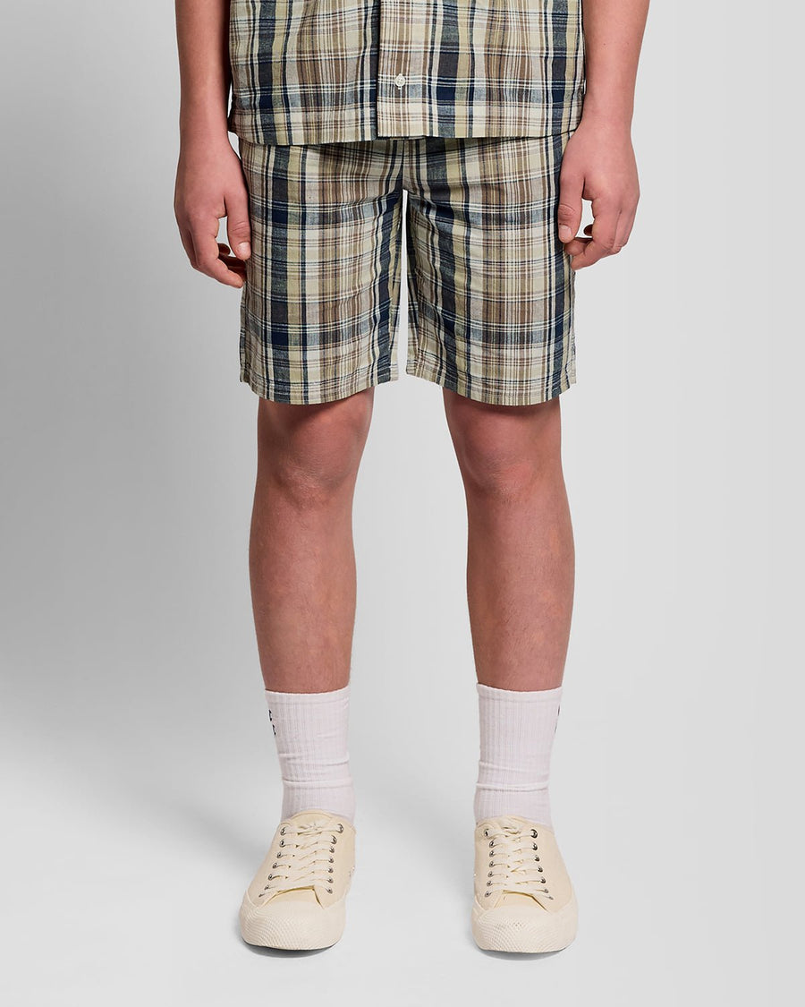 Uomo con pantaloncini a quadri in misto lino, colore verde erba