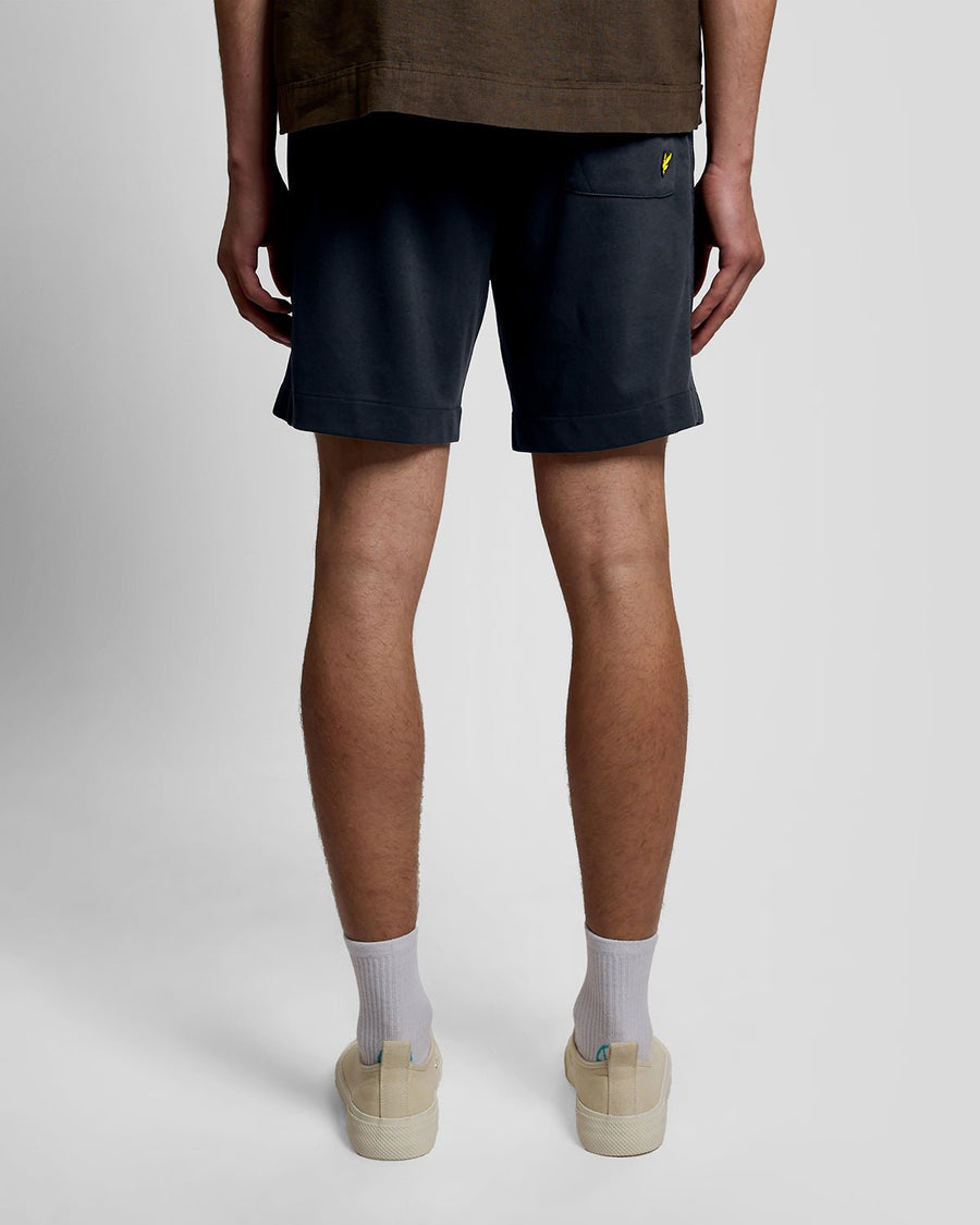 Un homme porte un short de survêtement Interlock bleu marine foncé