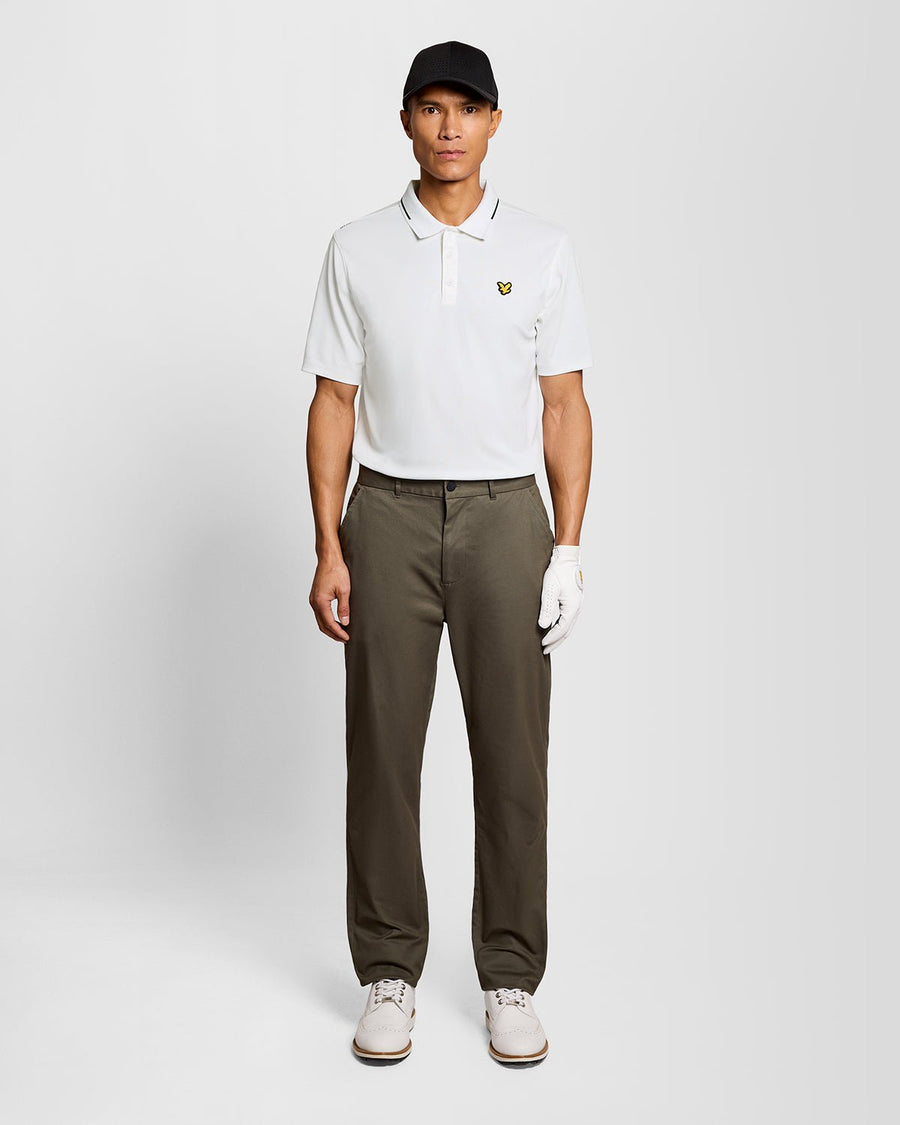 Un homme porte un polo technique à bordures contrastées, de couleur blanche