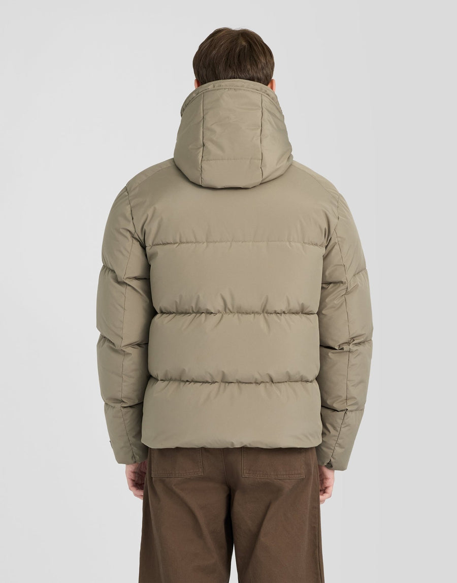 Mann trägt eine Kapuzen-Daunenjacke in der Farbe „Khaki Ash“