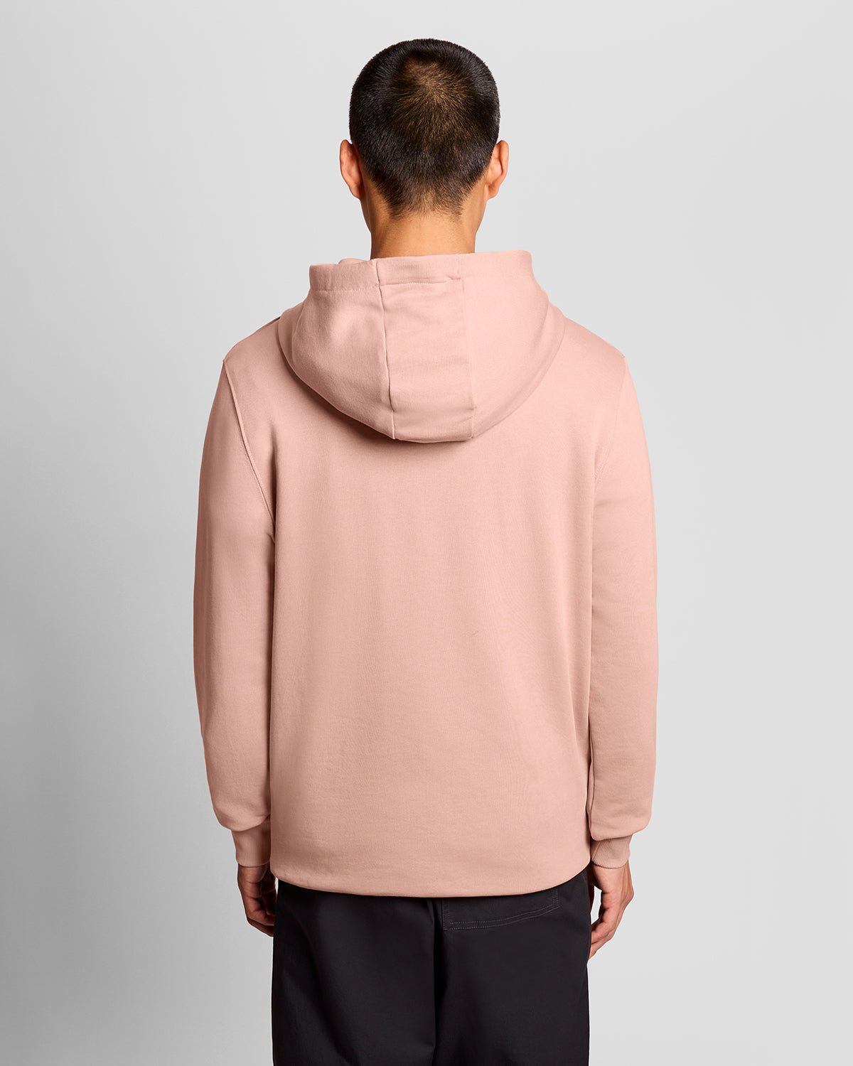 L'uomo indossa una felpa con cappuccio Loopback in cotone color rosa pompelmo