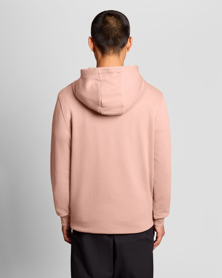 L'uomo indossa una felpa con cappuccio Loopback in cotone color rosa pompelmo