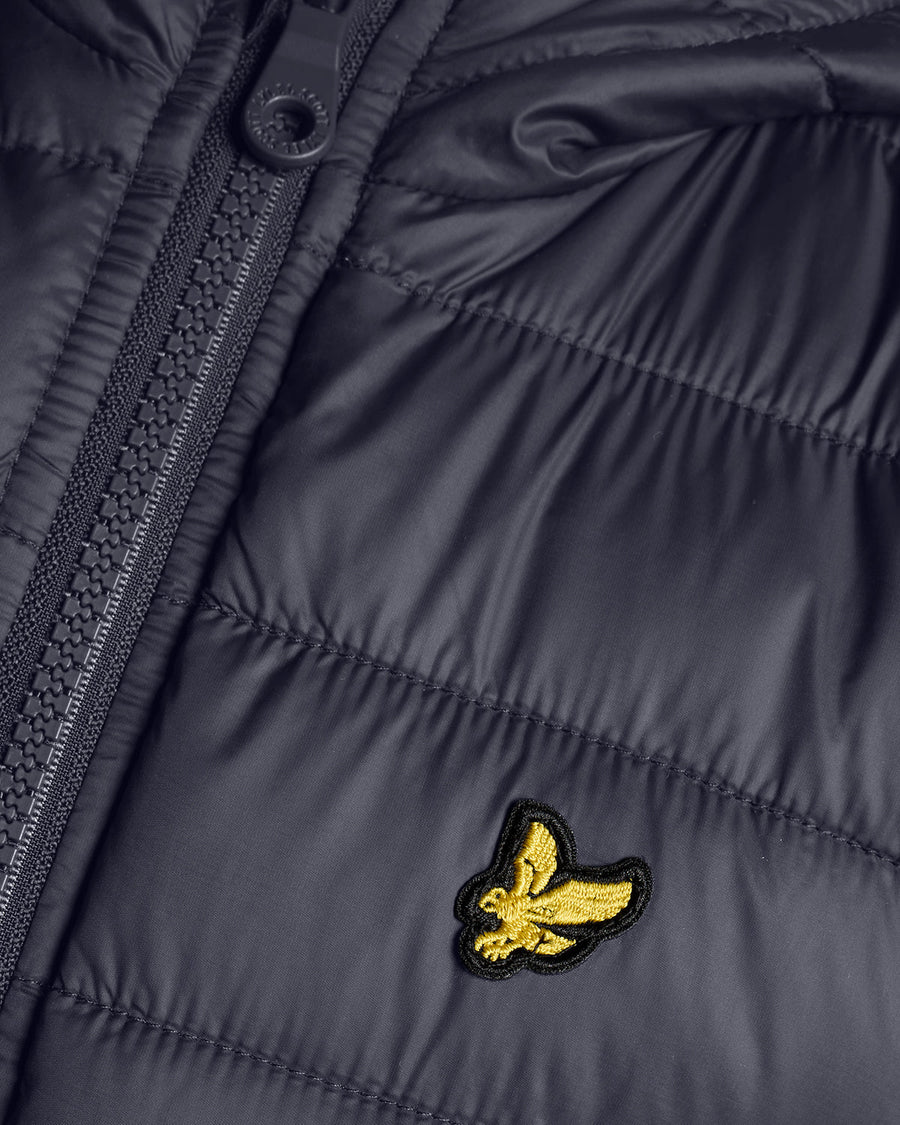 Junge trägt eine leichte, wattierte Jacke in Dunkelblau