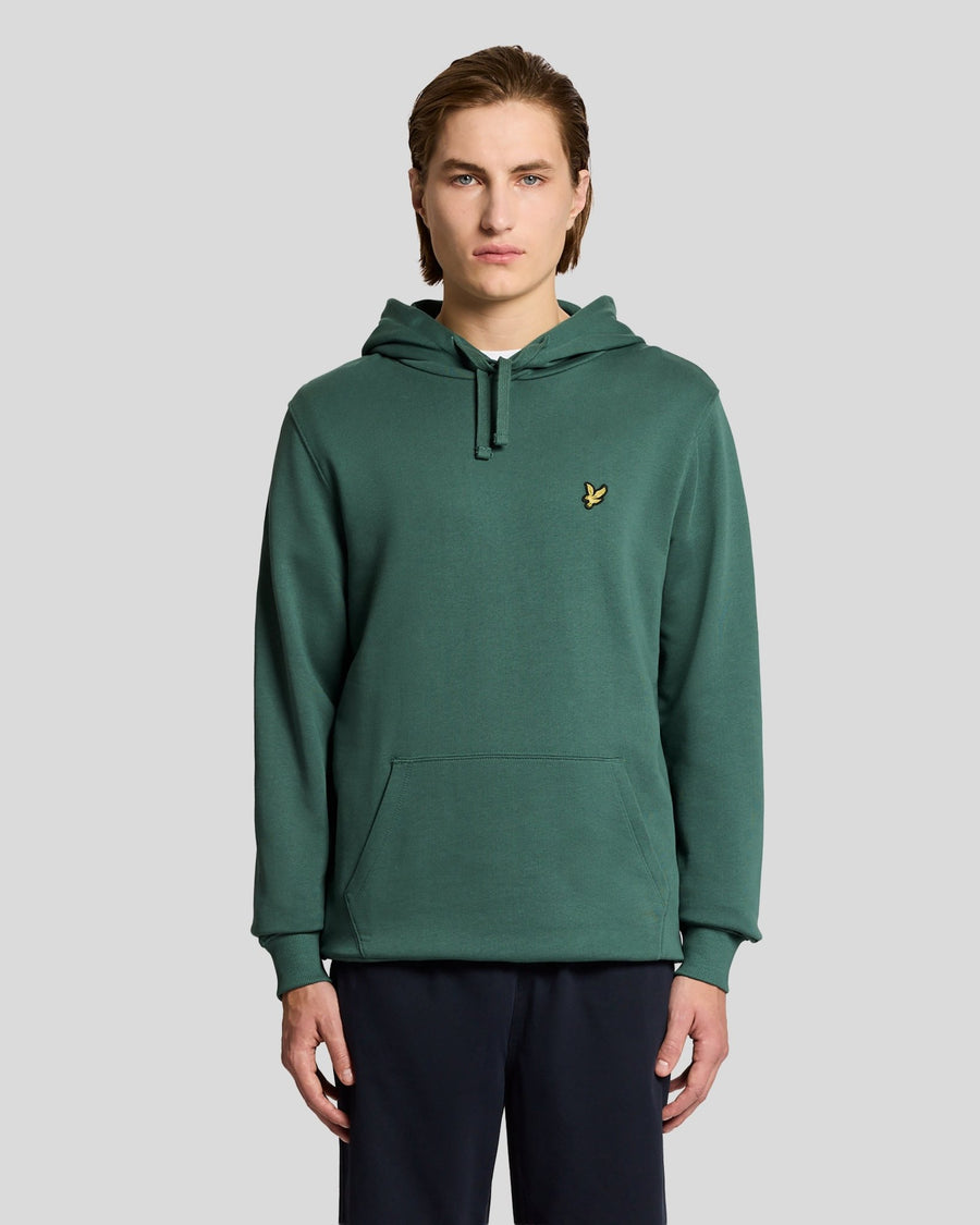 L'uomo indossa una felpa con cappuccio Loopback in cotone color Everglade