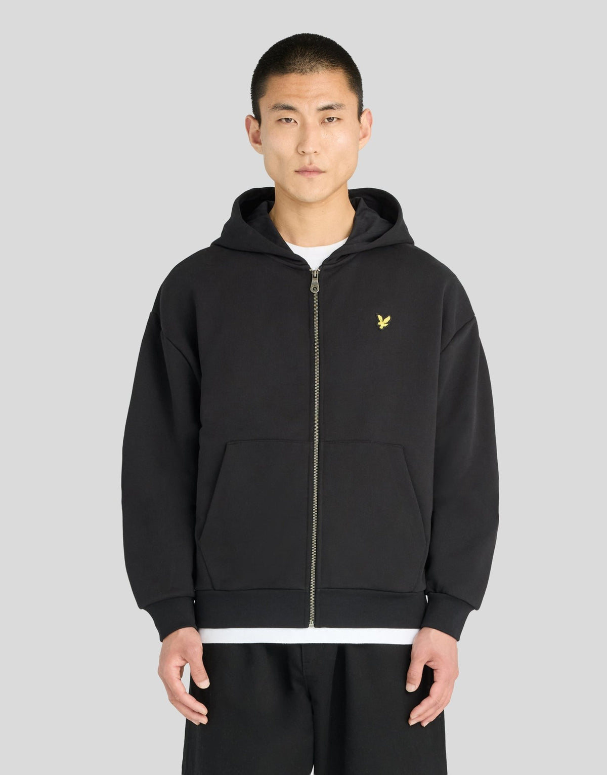 Man wears Heavyweight Loopback Zip Hoodie in Jet Black