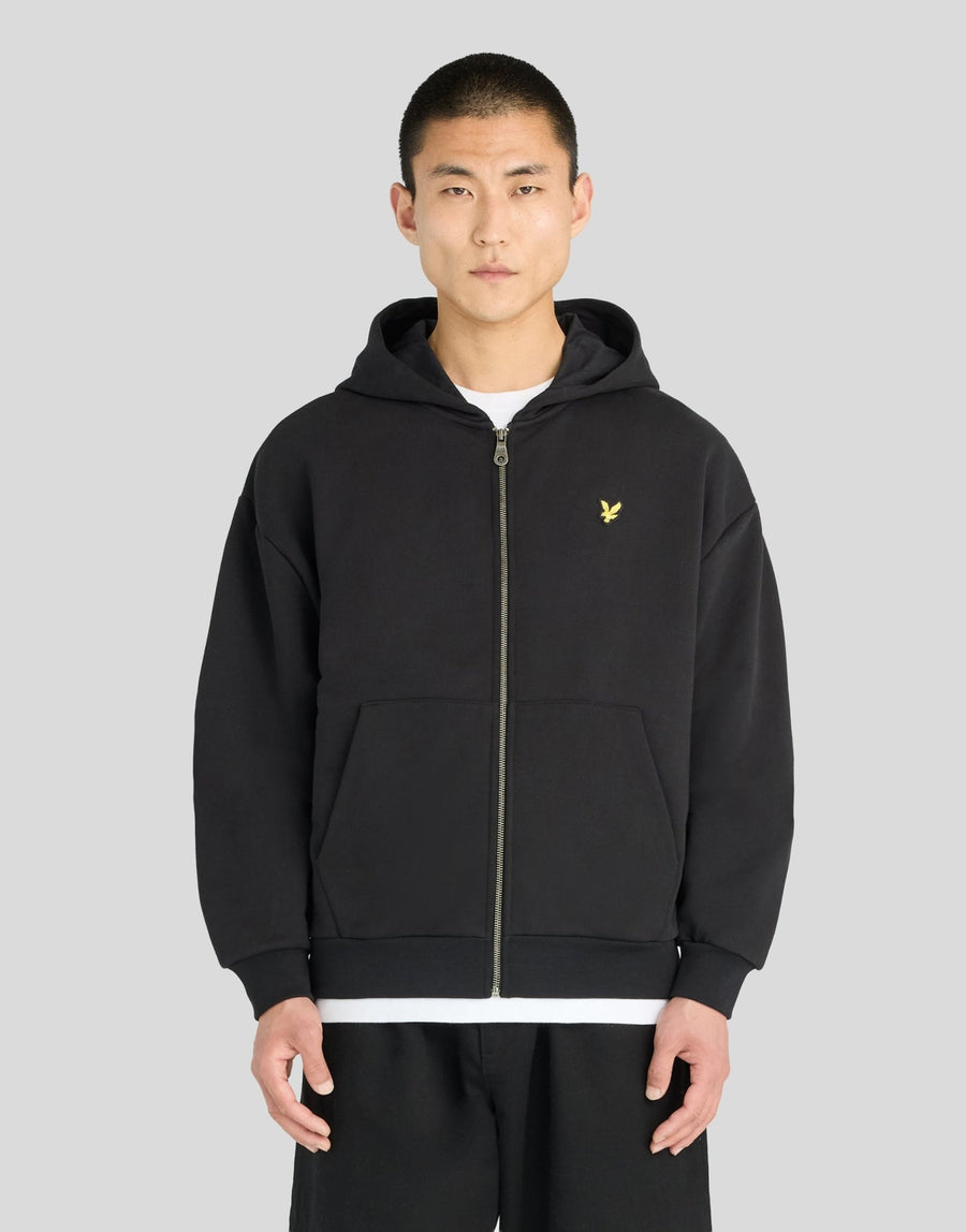 Man wears Heavyweight Loopback Zip Hoodie in Jet Black