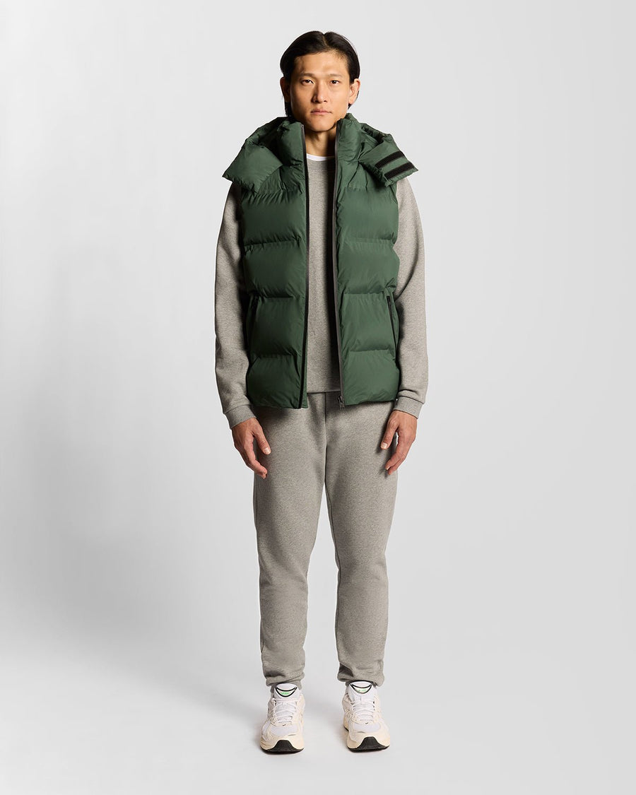 Homme portant un gilet matelassé à capuche épais, couleur Dark Pine