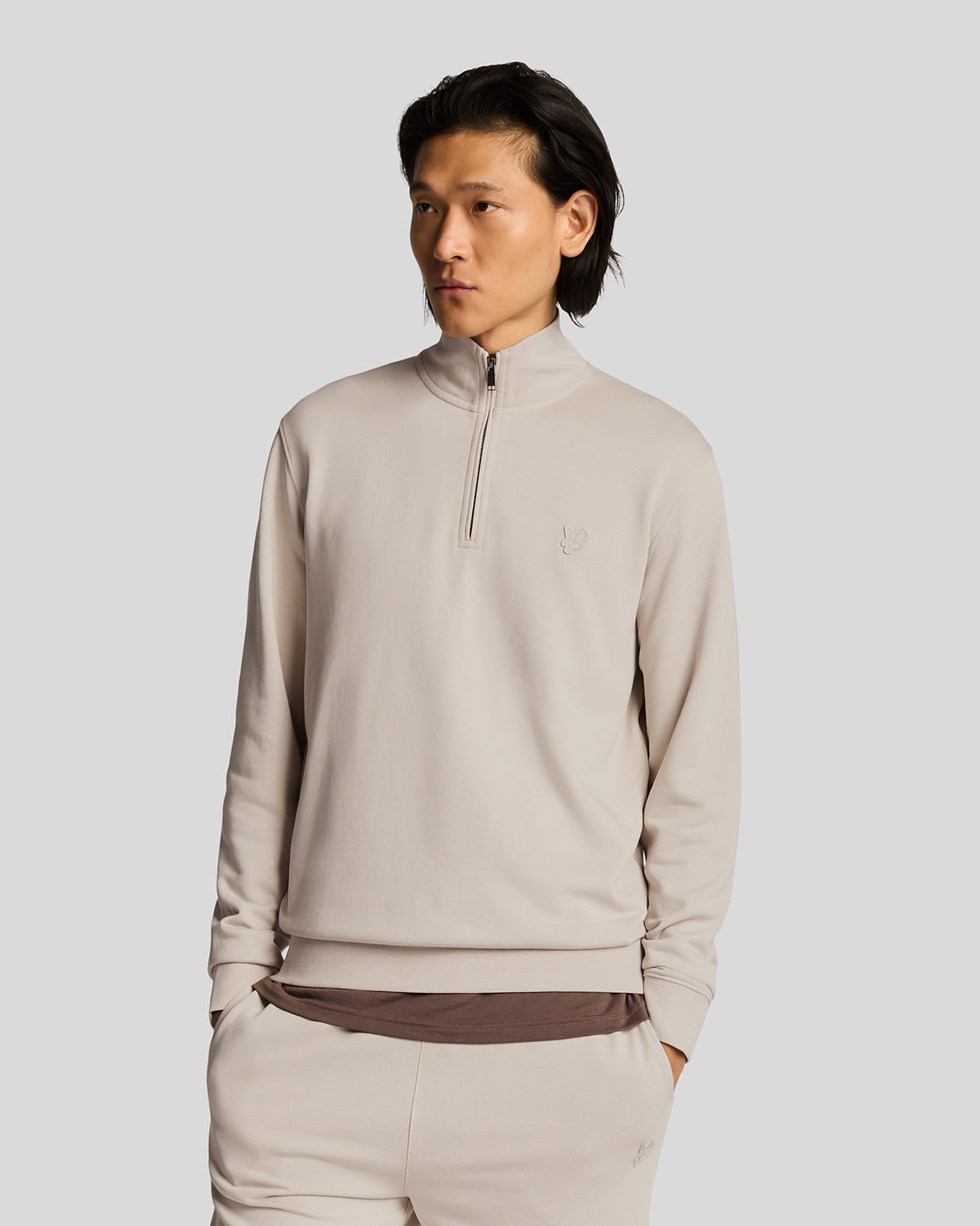 Un homme porte un sweat-shirt à fermeture éclair 1/4 en coton ultra-fin, couleur Cove