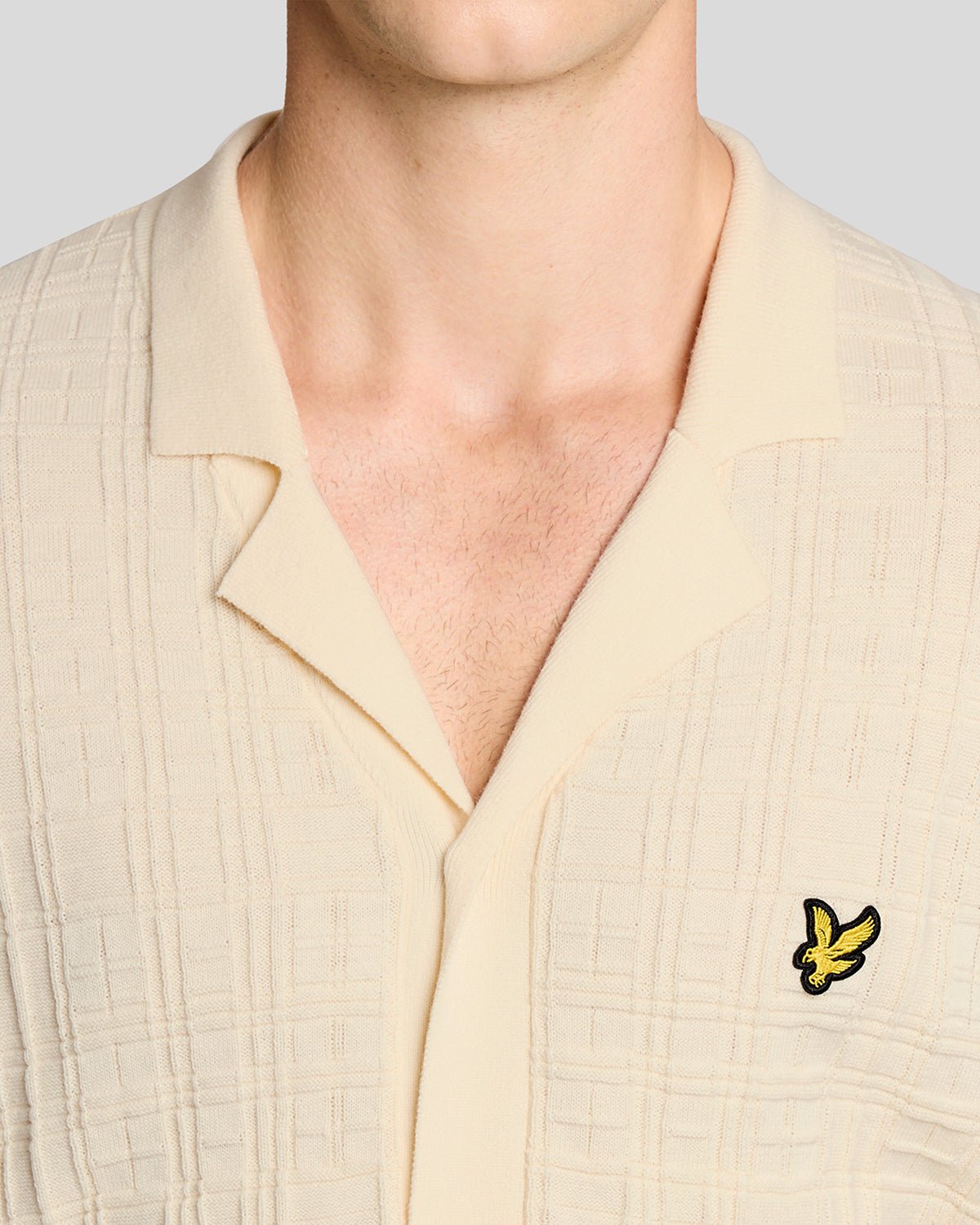 Un homme porte une chemise de vacances en maille à col Revere, couleur « Ice Cream »