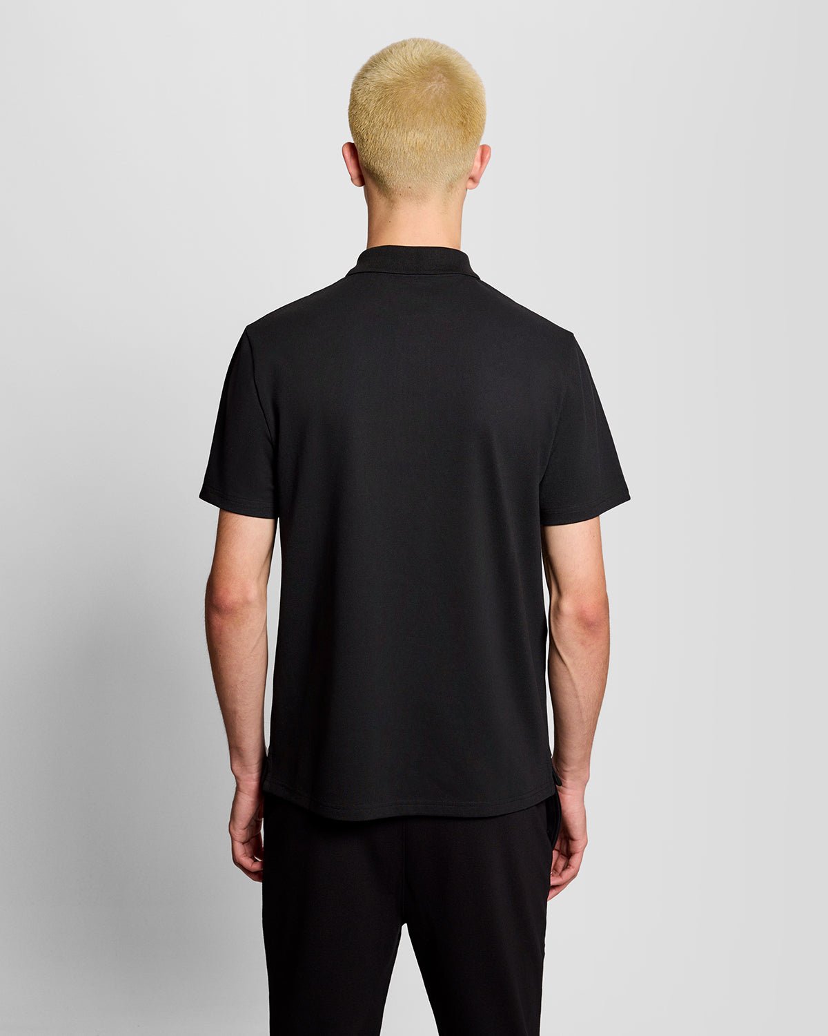 Un homme porte un polo de sport noir de jais