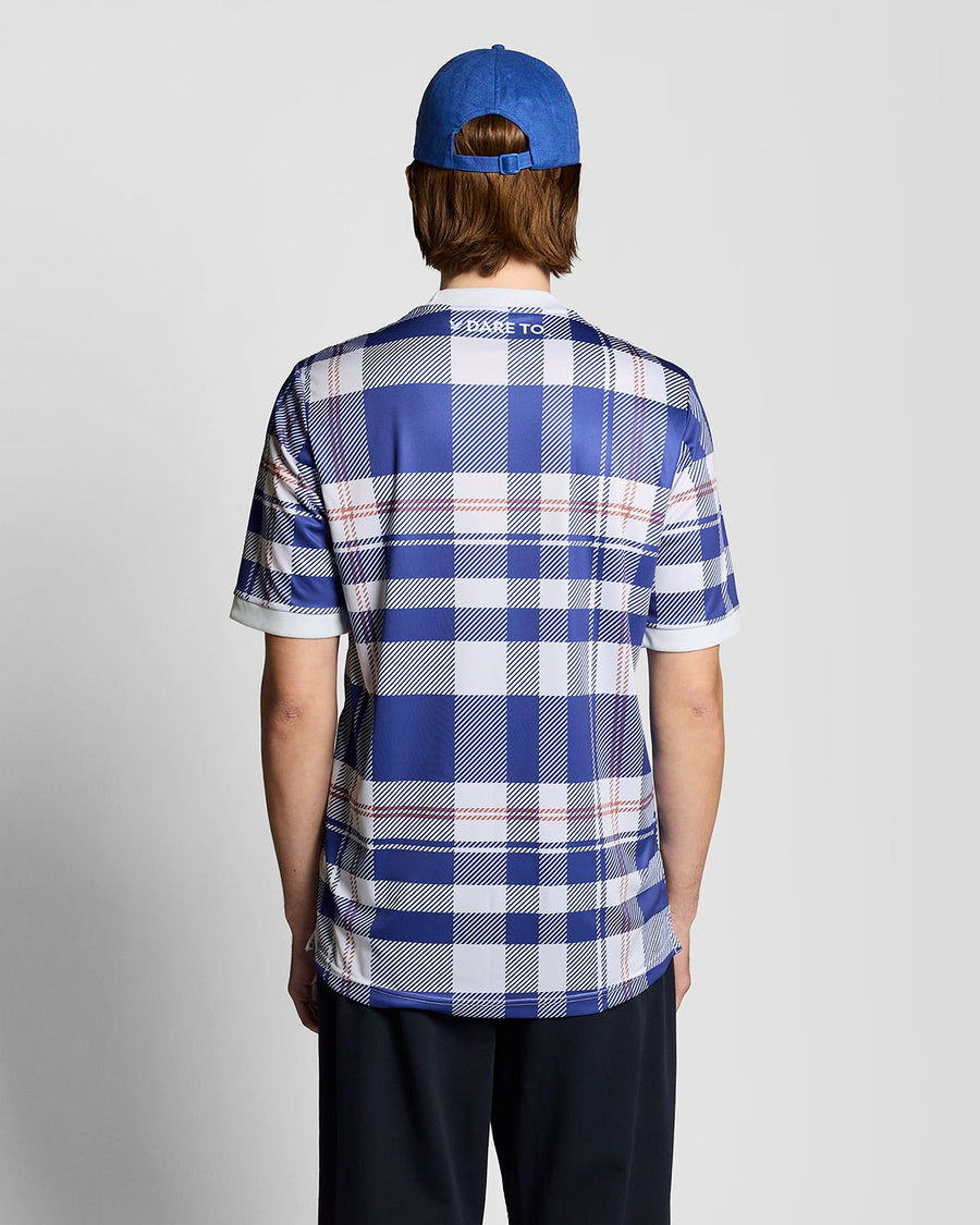 Homme portant un maillot de football à carreaux tartan de style sportif, couleur Now Blue