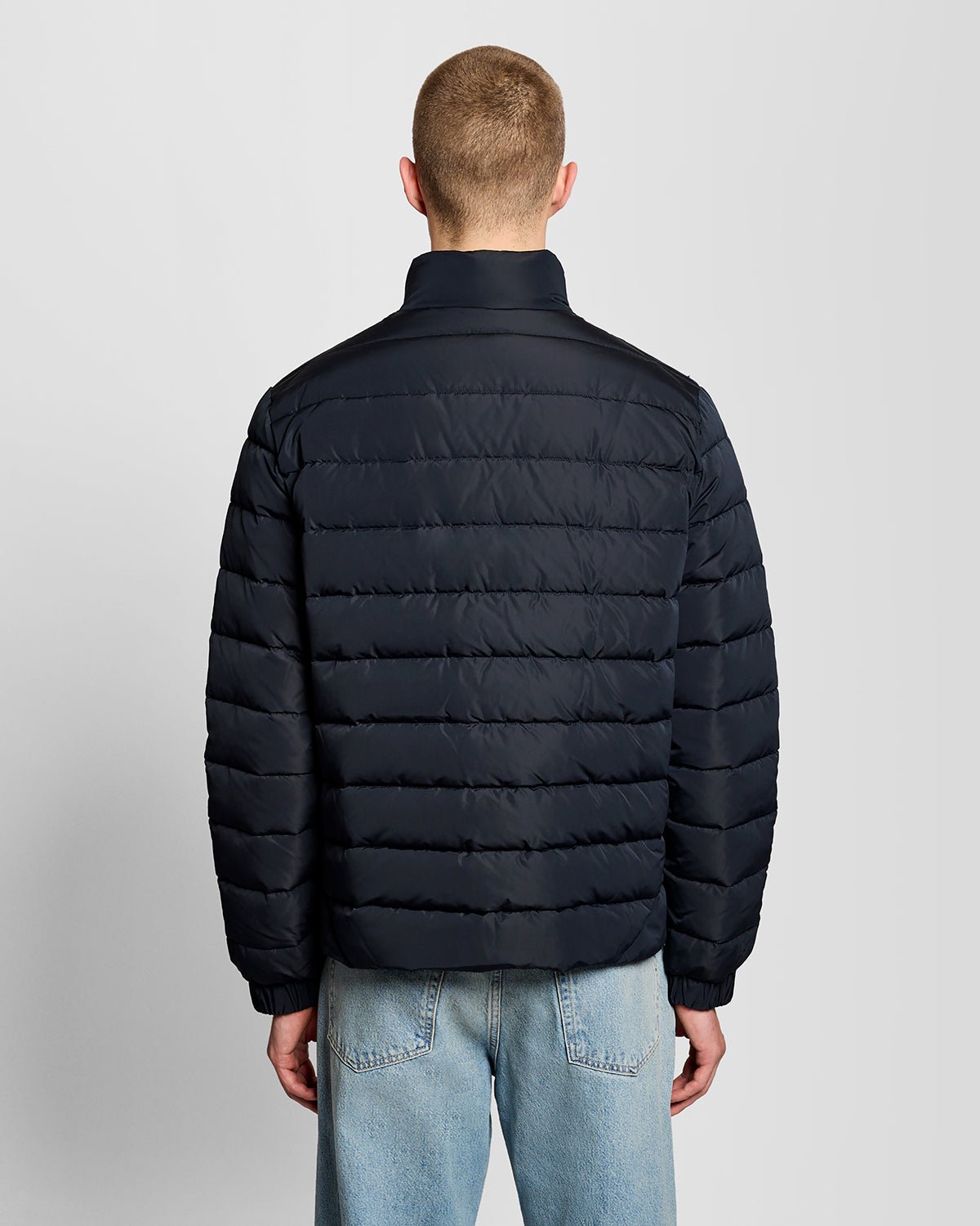 Un homme porte une veste matelassée bleu marine foncé