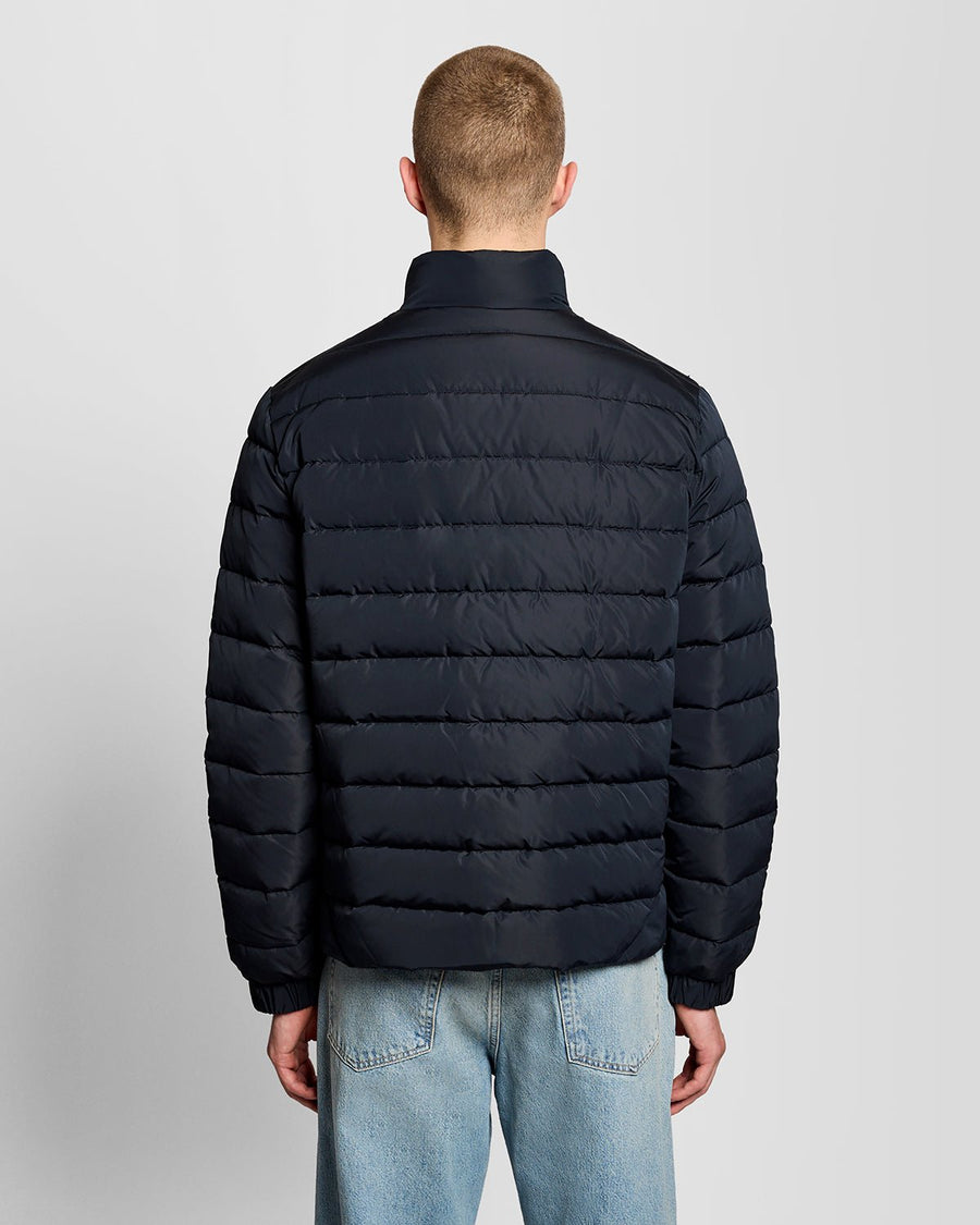Un homme porte une veste matelassée bleu marine foncé