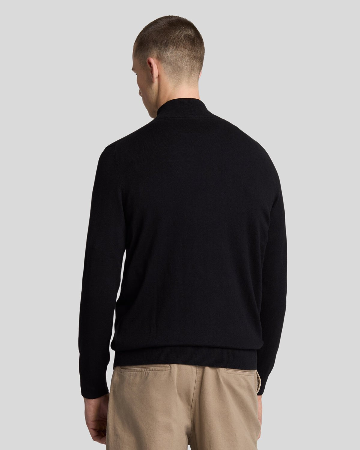Man wears Cotton Merino 1/4 Zip Jumper in Jet Black