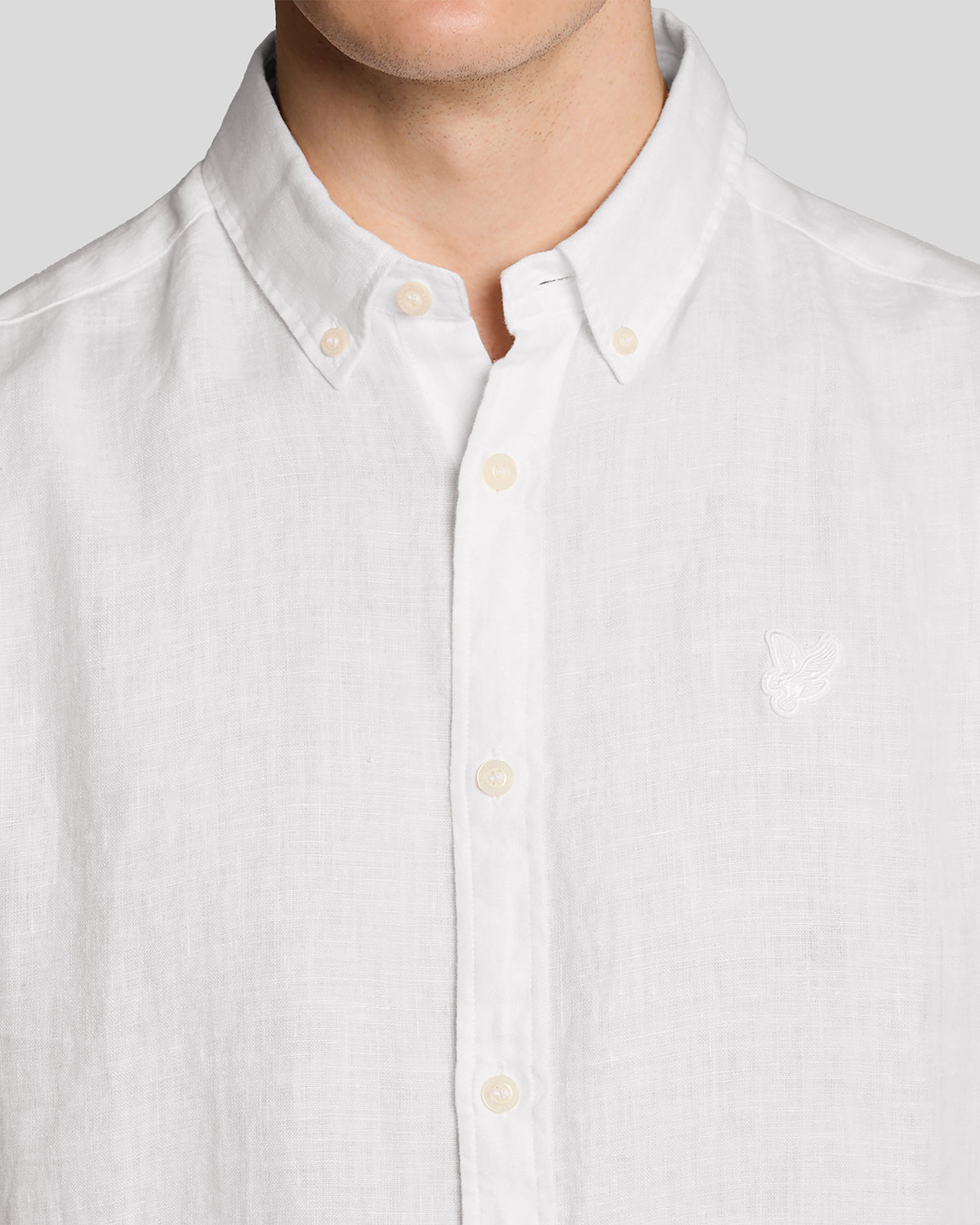 Un homme porte une chemise en lin à manches courtes blanche