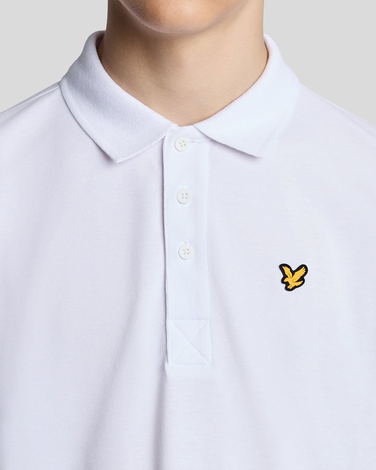 Un homme porte un polo de sport blanc