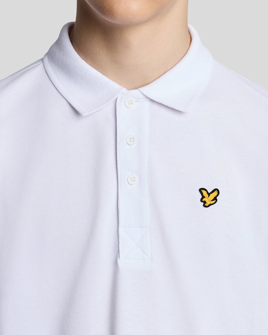 Un homme porte un polo de sport blanc