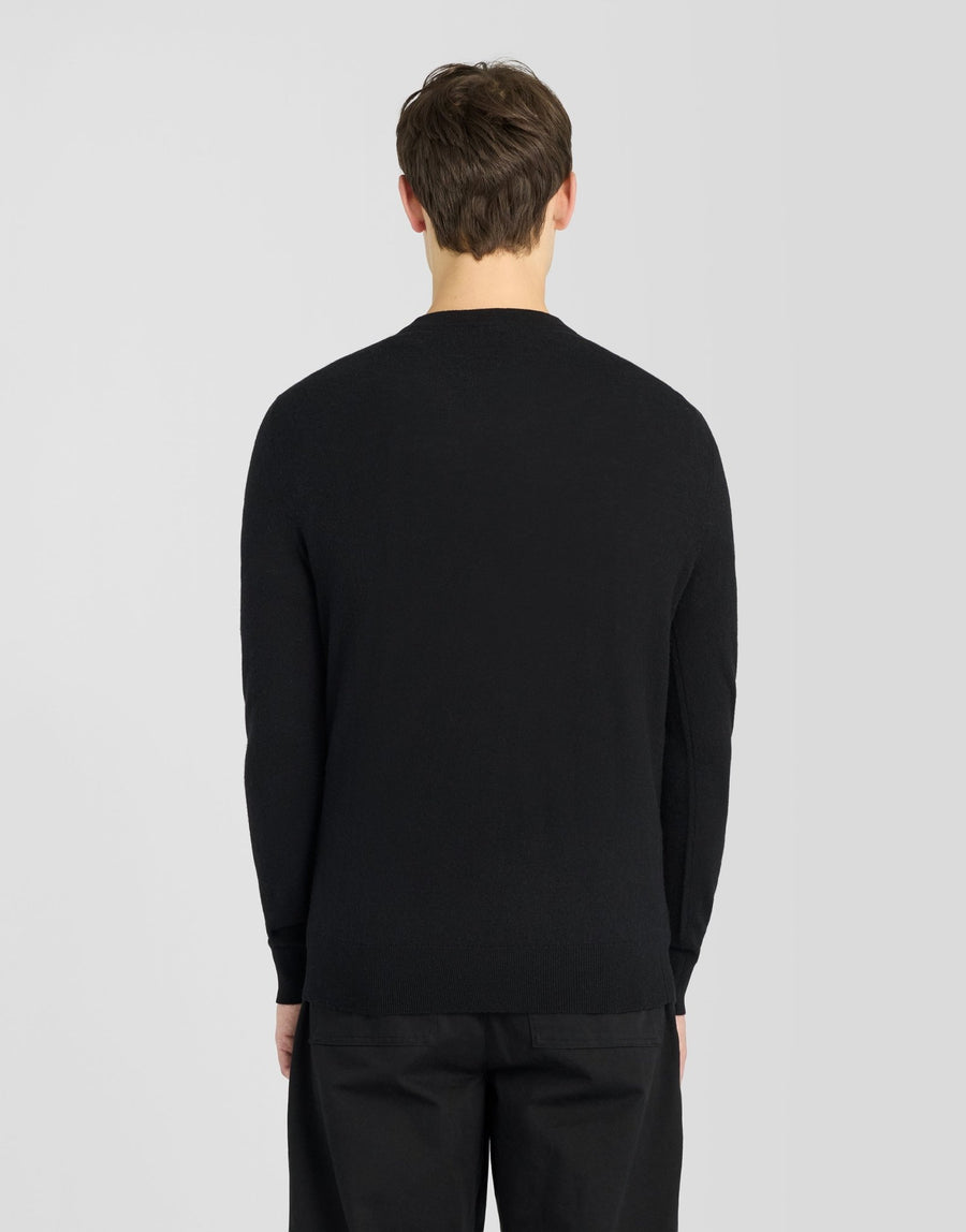 Man draagt een trui met ronde hals van lamswol in Jet Black