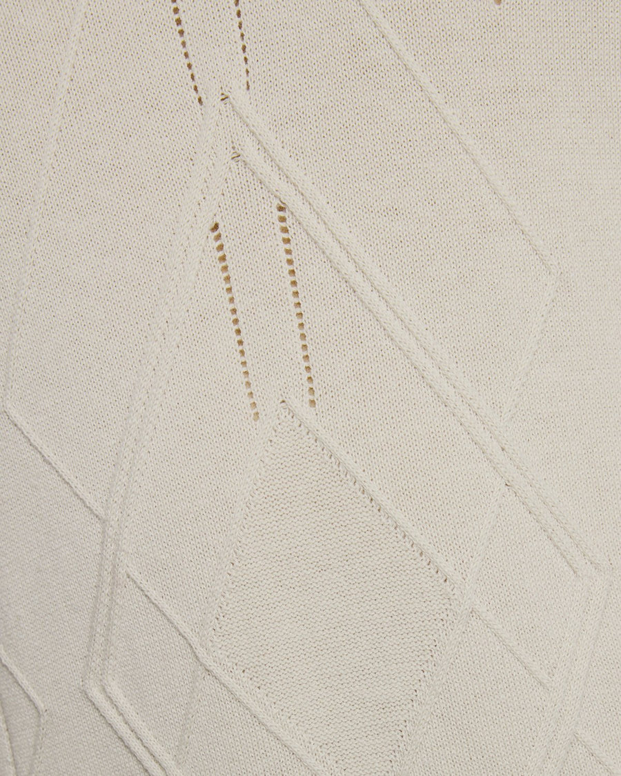 Un homme porte un polo en maille à motif argyle et col ouvert, couleur Cove