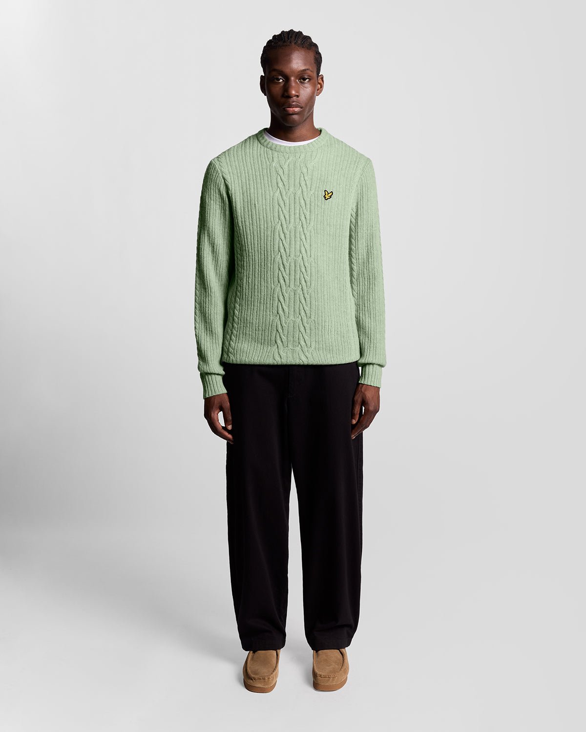 Un homme porte un pull en maille torsadée côtelée, couleur « Cold Mint Marl »