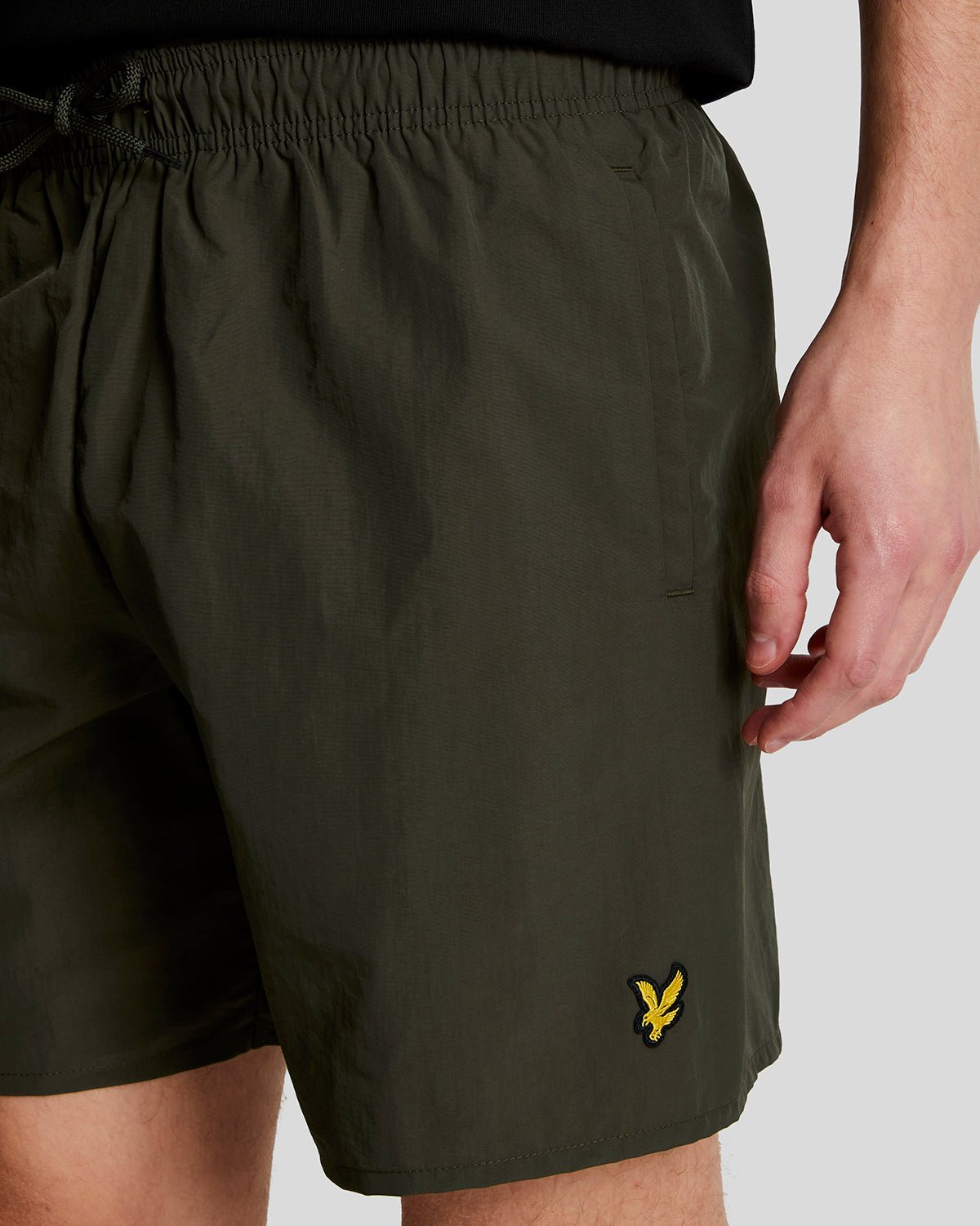 Man wears Plain Swim Shorts in Olive