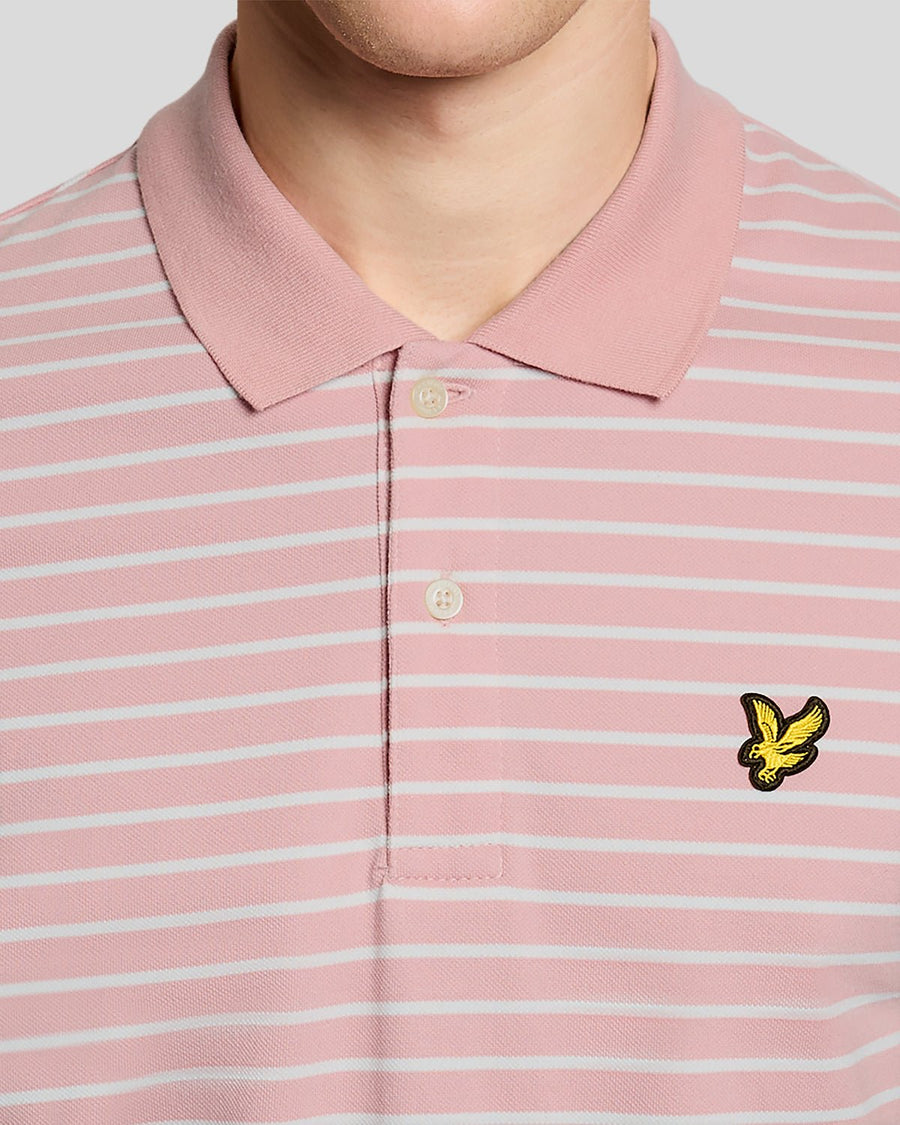 Homme portant un polo breton en piqué rose pamplemousse et blanc